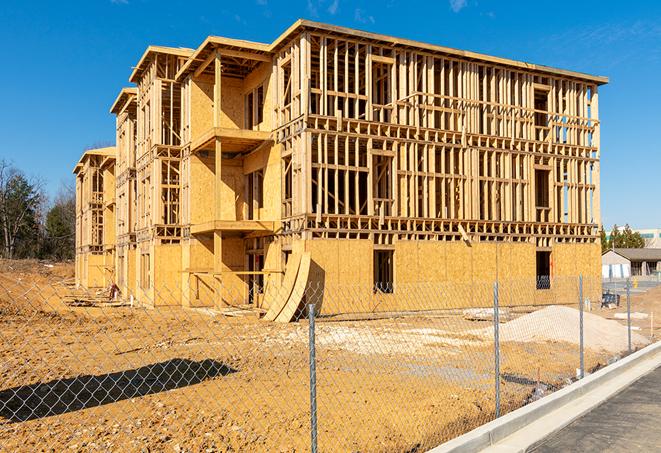 a close-up of temporary chain link fences enclosing a construction site, signaling progress in the project's development in Kalamazoo, MI